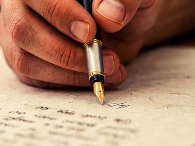 Hand writing on textured paper with a fountain pen in close-up